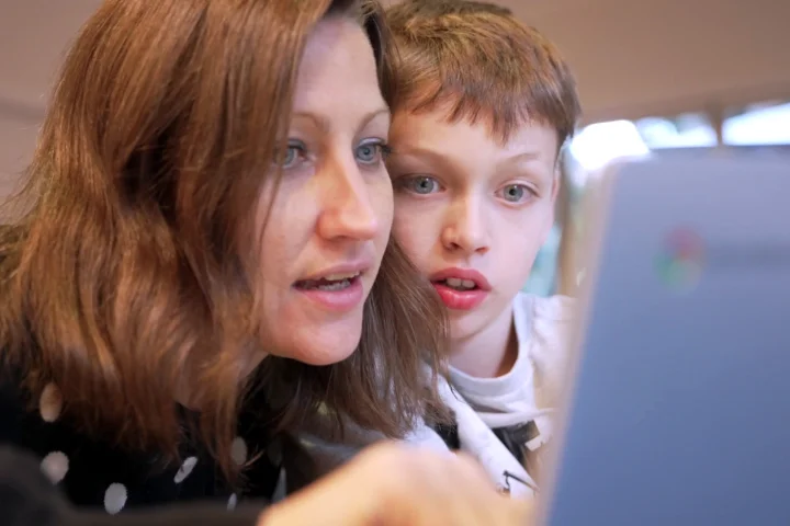 The Pack Leader online program shown on a laptop and phone alongside printed worksheets