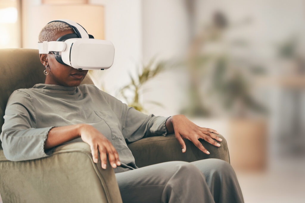 A woman sitting in an armchair wearing a virtual reality headset